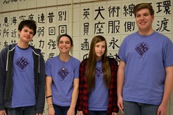 four students standing at wall of Japanese characters