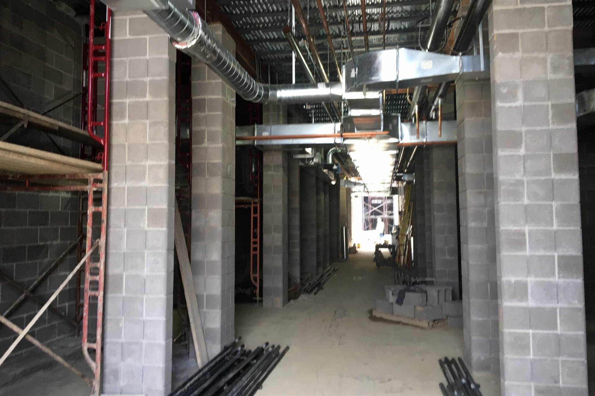 New school construction site with cinderblock hallway with exposed HVAC system