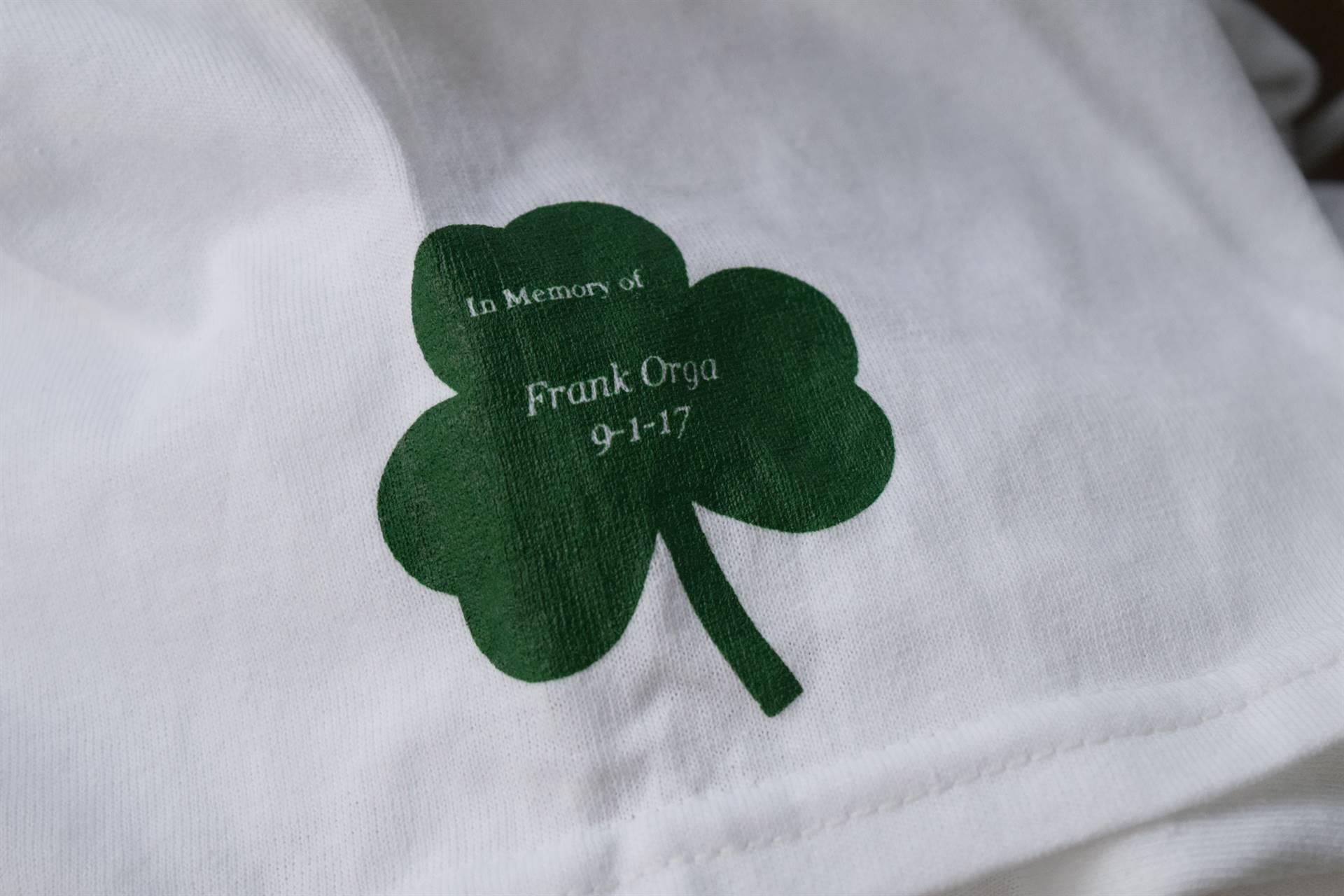Shamrock patch on race shirt sleeve in memory of Frank Orgs