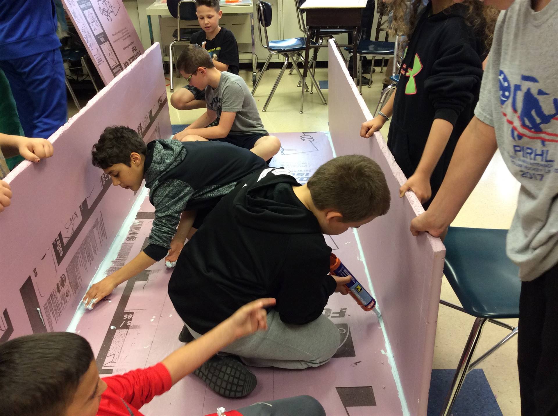 a group of boys creating a large container