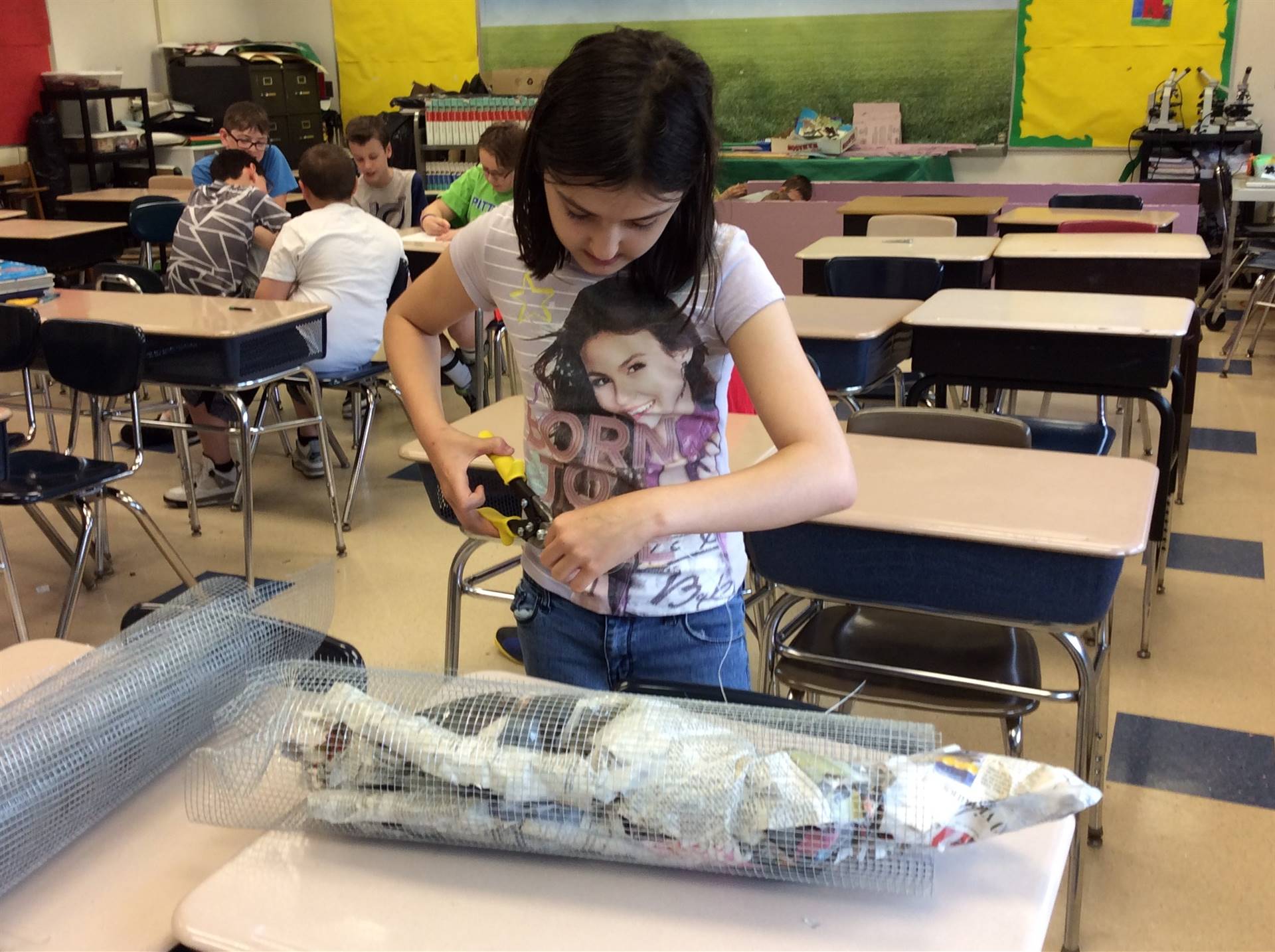 a girl covering paper mache with wire