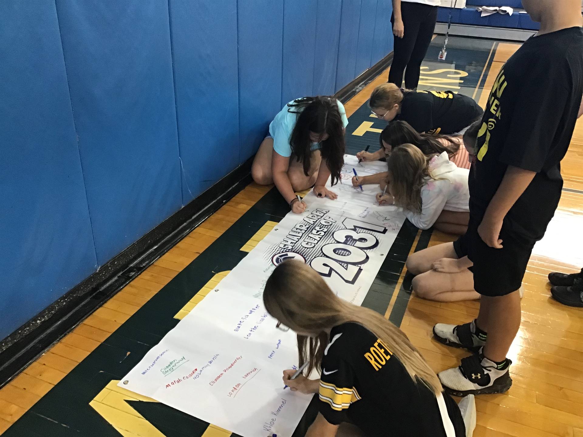 4th graders signing a banner