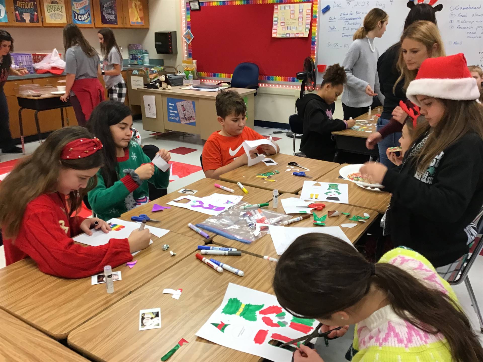 Students cutting paper for craft at holiday party