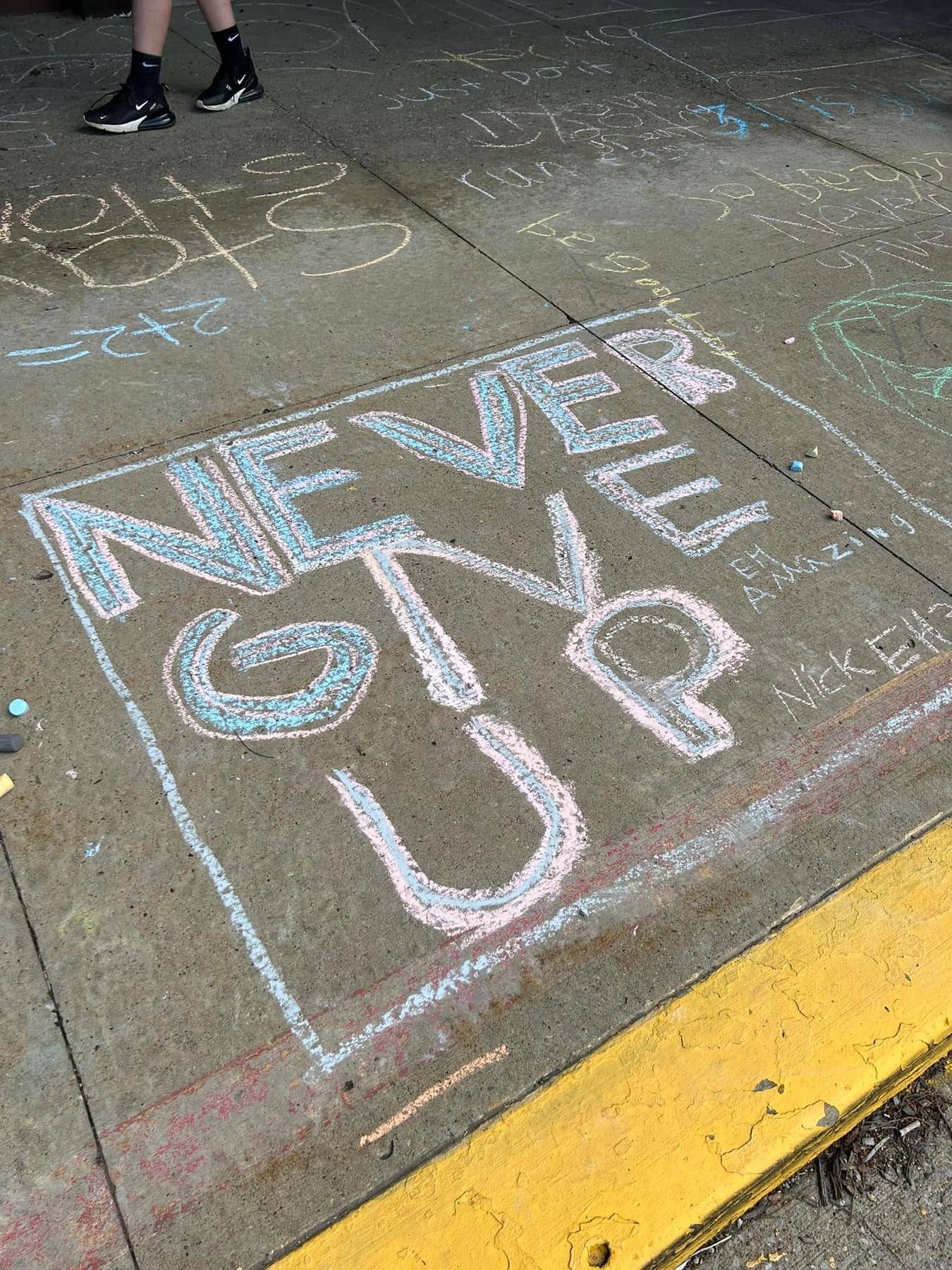 Chalk sign “Never Give Up”.